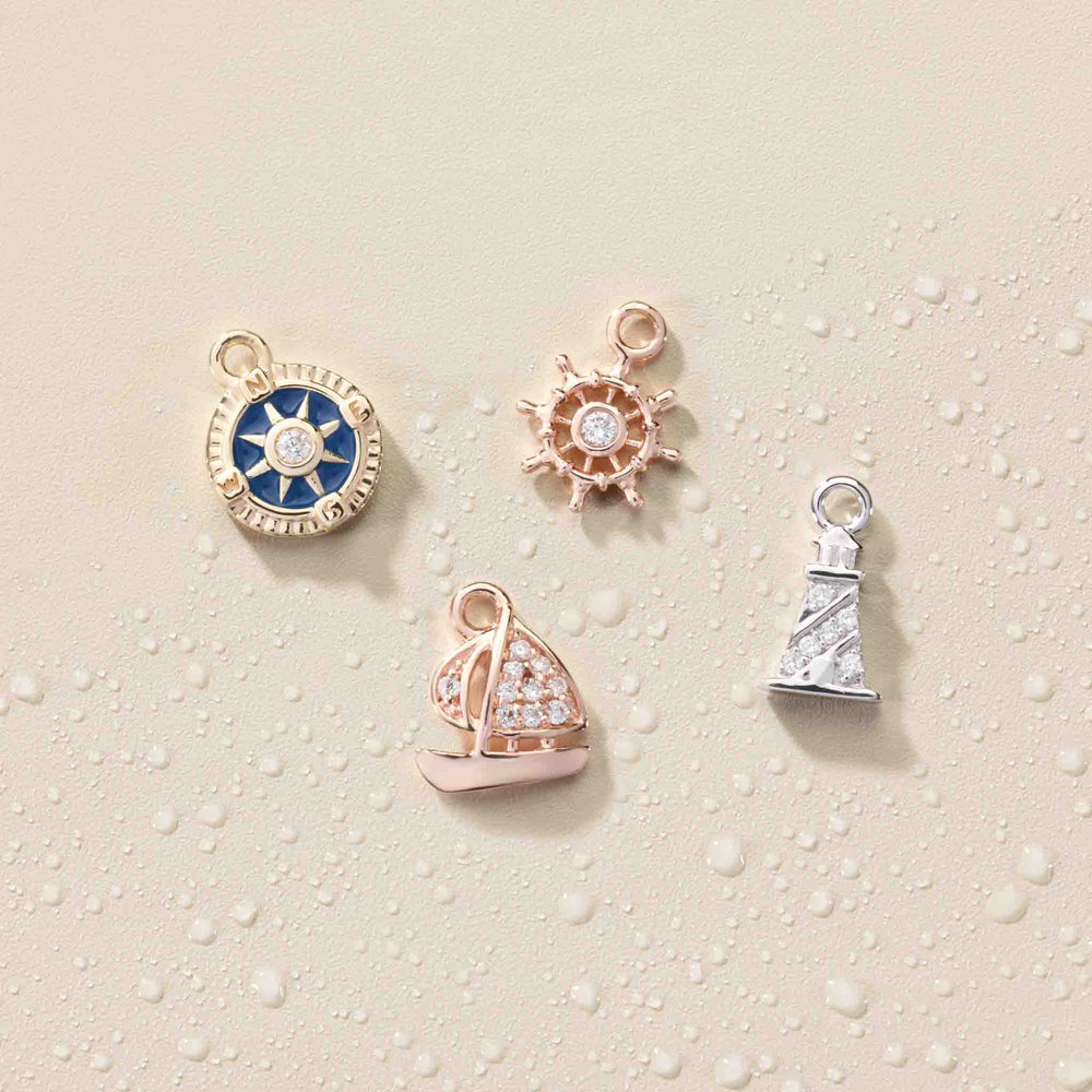 14k gold miniature diamond blue enamel compass, ship wheel, sailboat, lighthouse dangle showcase.
