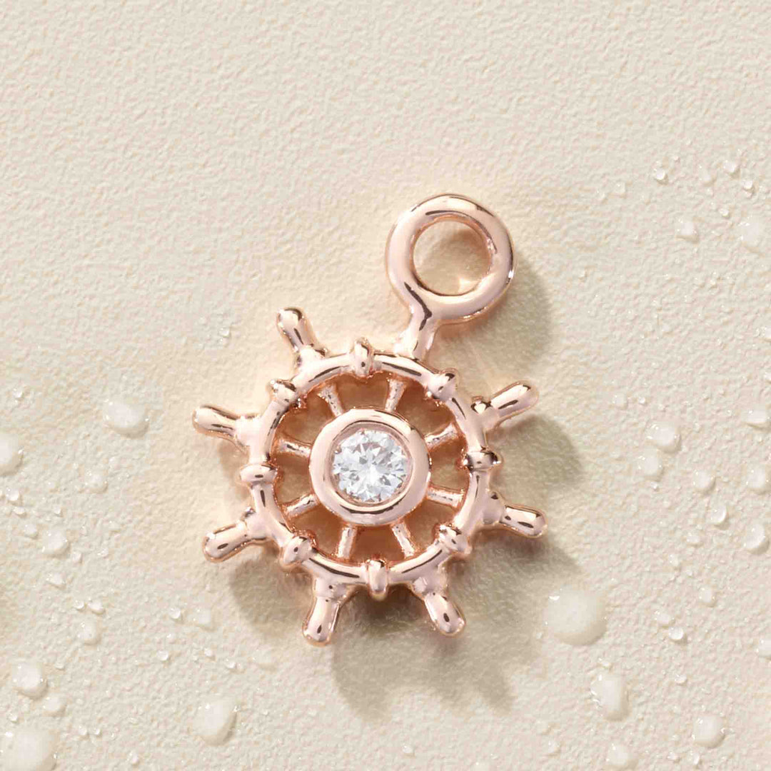 14K rose gold miniature diamond ship wheel dangle.